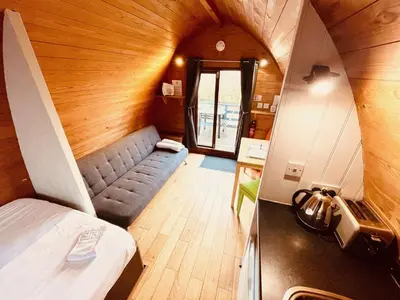 a small room with a bed and a couch at MegaPod 2 at Lee Wick Farm Cottages & Glamping in Clacton-on-Sea