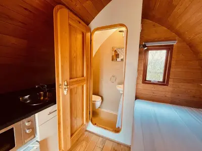 a small bathroom with a toilet and a sink at MegaPod 2 at Lee Wick Farm Cottages & Glamping in Clacton-on-Sea