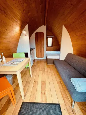 a living room with a couch and a table at MegaPod 2 at Lee Wick Farm Cottages & Glamping in Clacton-on-Sea