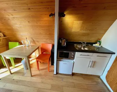 a small kitchen with a table and a sink at MegaPod 1 at Lee Wick Farm Cottages & Glamping in Clacton-on-Sea
