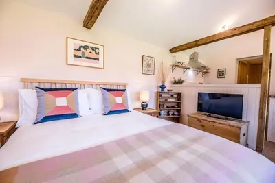a bedroom with a large bed and a tv at The Studio, Hoo in Woodbridge