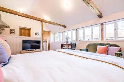 a large bedroom with a large bed and a tv at The Studio, Hoo in Woodbridge