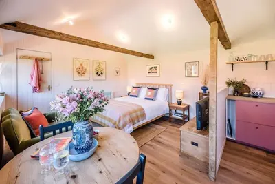 a bedroom with a bed and a table with flowers on it at The Studio, Hoo in Woodbridge