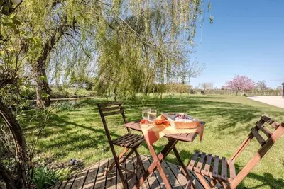 a picnic table with two chairs in a park at The Studio, Hoo in Woodbridge