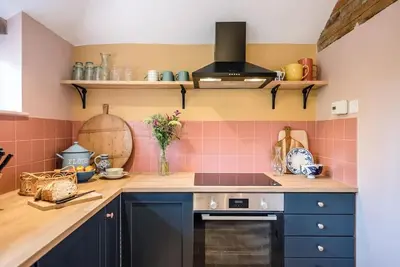 a kitchen with pink tiles on the wall at The Stables, Hoo in Woodbridge