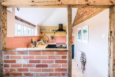 a brick kitchen with a sink and a brick wall at The Stables, Hoo in Woodbridge
