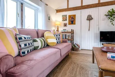 a living room with a purple couch with pillows at The Stables, Hoo in Woodbridge