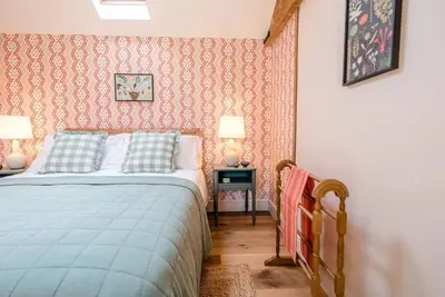 a bedroom with a bed and two lamps in it at The Stables, Hoo in Woodbridge