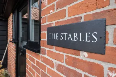 a sign on the side of a brick building at The Stables, Hoo in Woodbridge