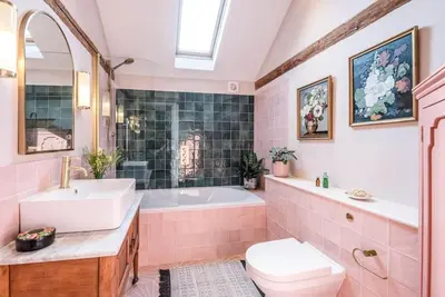 a pink bathroom with a tub and a sink and a toilet at The Stables, Hoo in Woodbridge