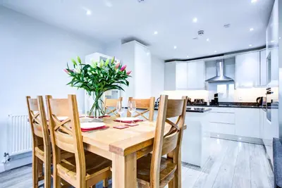 a kitchen and dining room with a wooden table and chairs at leigh Penthouse Apartment in Leigh-on-Sea
