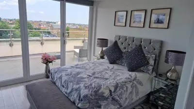 a bedroom with a bed and a large window at leigh Penthouse Apartment in Leigh-on-Sea