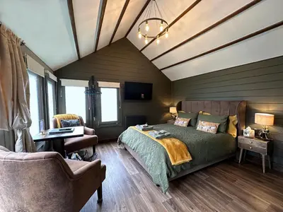a bedroom with a bed and a desk and chairs at The Cabin Near Stansted Airport in Little Hallingbury