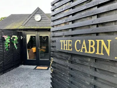 a sign that says the cabin on the side of a building at The Cabin Near Stansted Airport in Little Hallingbury