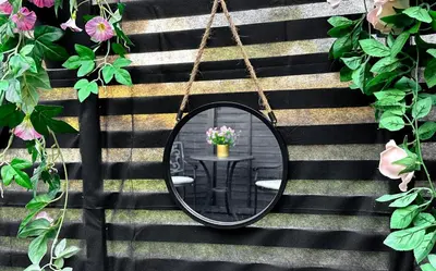 a mirror hanging on a wall with a table at The Cabin Near Stansted Airport in Little Hallingbury