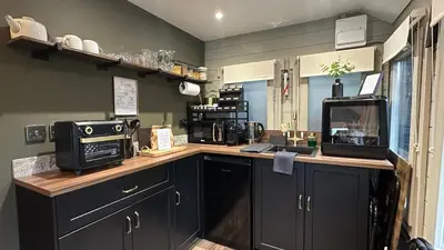 a kitchen with a counter top with a microwave at The Cabin Near Stansted Airport in Little Hallingbury
