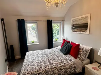 a bedroom with a bed and two windows at Luxury Retreat Beach House - Sleeps 6 in Southend-on-Sea