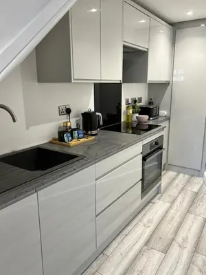 a kitchen with white cabinets and black counter tops at Luxury Retreat Beach House - Sleeps 6 in Southend-on-Sea