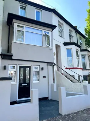 a white house with a black door and stairs at Luxury Retreat Beach House - Sleeps 6 in Southend-on-Sea