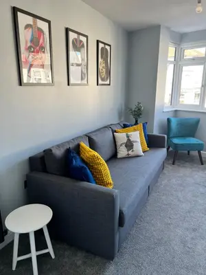 a living room with a gray couch and a table at Luxury Retreat Beach House - Sleeps 6 in Southend-on-Sea
