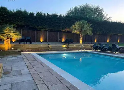 a swimming pool in a backyard with chairs and trees at Large Countryside House Swim Pool Jacuzzi Sleeps 10 guest in Ware