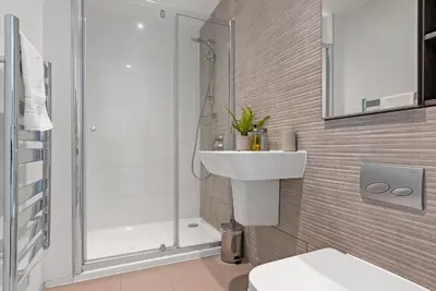 a white bathroom with a shower and a sink at Tailored Stays - Central Cambridge, River Walk Apartments in Cambridge