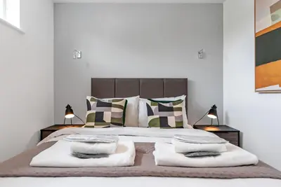 a white bedroom with a large bed with pillows at Tailored Stays - Central Cambridge, River Walk Apartments in Cambridge