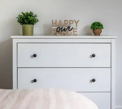 a white dresser with two potted plants on top of it at Shore House - Walton in Walton-on-the-Naze