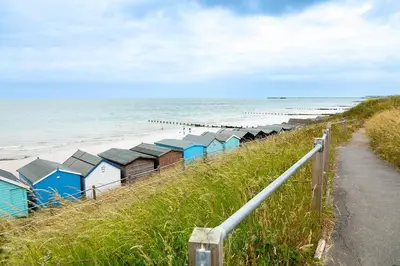 a row of beach huts next to the ocean at Shore House - Walton in Walton-on-the-Naze