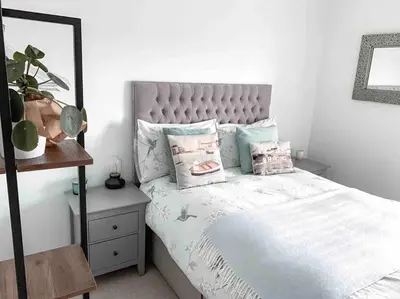 a bedroom with a bed with pillows on it at Victorian quirky farm cottage next to forest & close to beach in Woodbridge