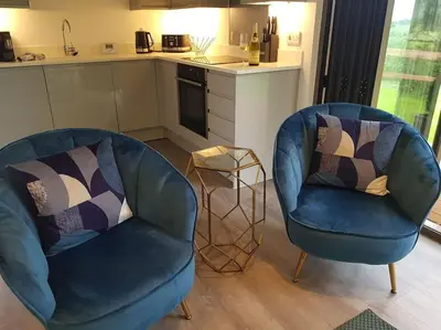 two blue chairs in a kitchen with a counter at Landscape, New Eco Lodge Flatford Mill in East Bergholt