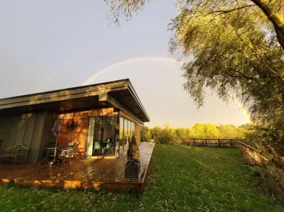 a small house with a deck in a field at Landscape, New Eco Lodge Flatford Mill in East Bergholt