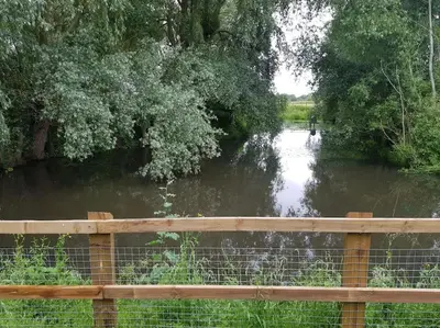 a river with a fence in front of it at Landscape, New Eco Lodge Flatford Mill in East Bergholt
