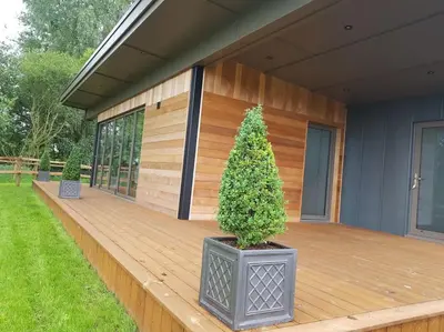 a house with a wooden deck with a christmas tree on it at Landscape, New Eco Lodge Flatford Mill in East Bergholt