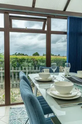 a table with chairs and a view of a vineyard at 2 Bedroom Rural Escape In Peaceful Elmswell in Woolpit