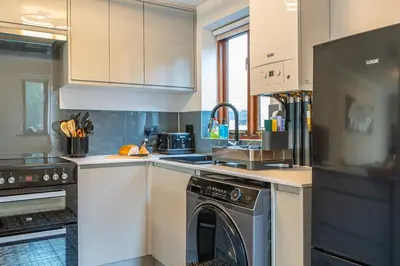 a kitchen with white cabinets and a dishwasher at 2 Bedroom Rural Escape In Peaceful Elmswell in Woolpit