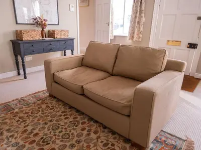 a brown couch in a living room with a table at The Old Reading Rooms Linton in Linton