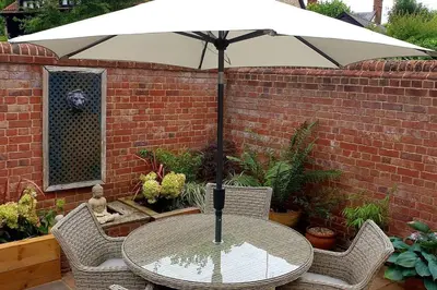 a table with an umbrella on a patio at The Old Reading Rooms Linton in Linton