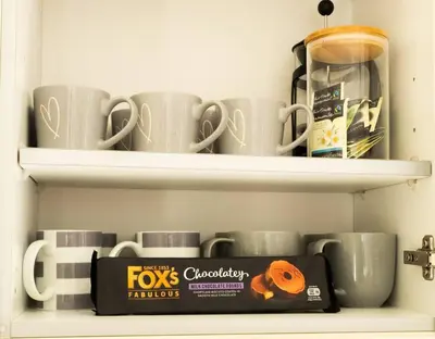 a shelf with mugs and a box on it at The Old Reading Rooms Linton in Linton