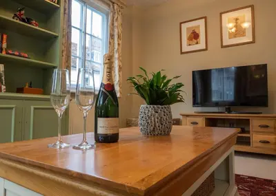 a bottle of wine and two glasses on a table at The Old Reading Rooms Linton in Linton