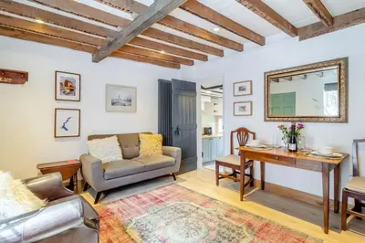 a living room with a couch and a table at Curlew Cottage Woodbridge Suffolk Cosy Victorian cottage for couple and dog in Woodbridge