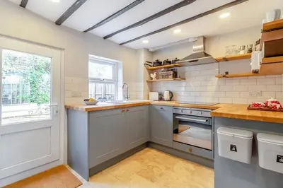 a kitchen with white appliances and a window at Curlew Cottage Woodbridge Suffolk Cosy Victorian cottage for couple and dog in Woodbridge