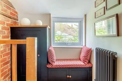 a small room with a chair and a window at Curlew Cottage Woodbridge Suffolk Cosy Victorian cottage for couple and dog in Woodbridge