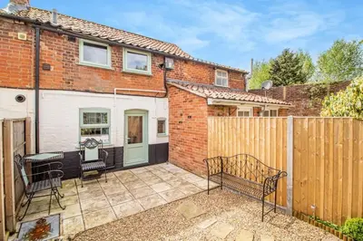 a patio with a bench and a fence at Curlew Cottage Woodbridge Suffolk Cosy Victorian cottage for couple and dog in Woodbridge