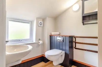 a bathroom with a white toilet and a sink at Curlew Cottage Woodbridge Suffolk Cosy Victorian cottage for couple and dog in Woodbridge