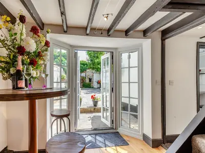 a dining room with a table and a glass door at Cutters Cottage in Roydon