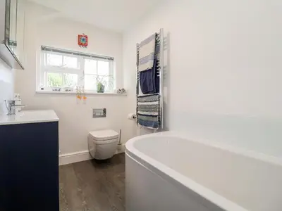 a bathroom with a tub and a toilet and a sink at Cavan Cottage in Saxmundham