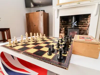 a chess board on a table in a room with a fireplace at Cavan Cottage in Saxmundham