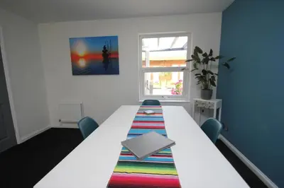 a room with a long white table and a window at The Zen Den in Southend-on-Sea