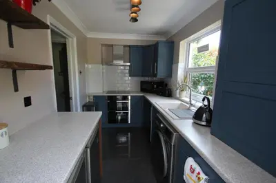 a kitchen with blue cabinets and a sink at The Zen Den in Southend-on-Sea